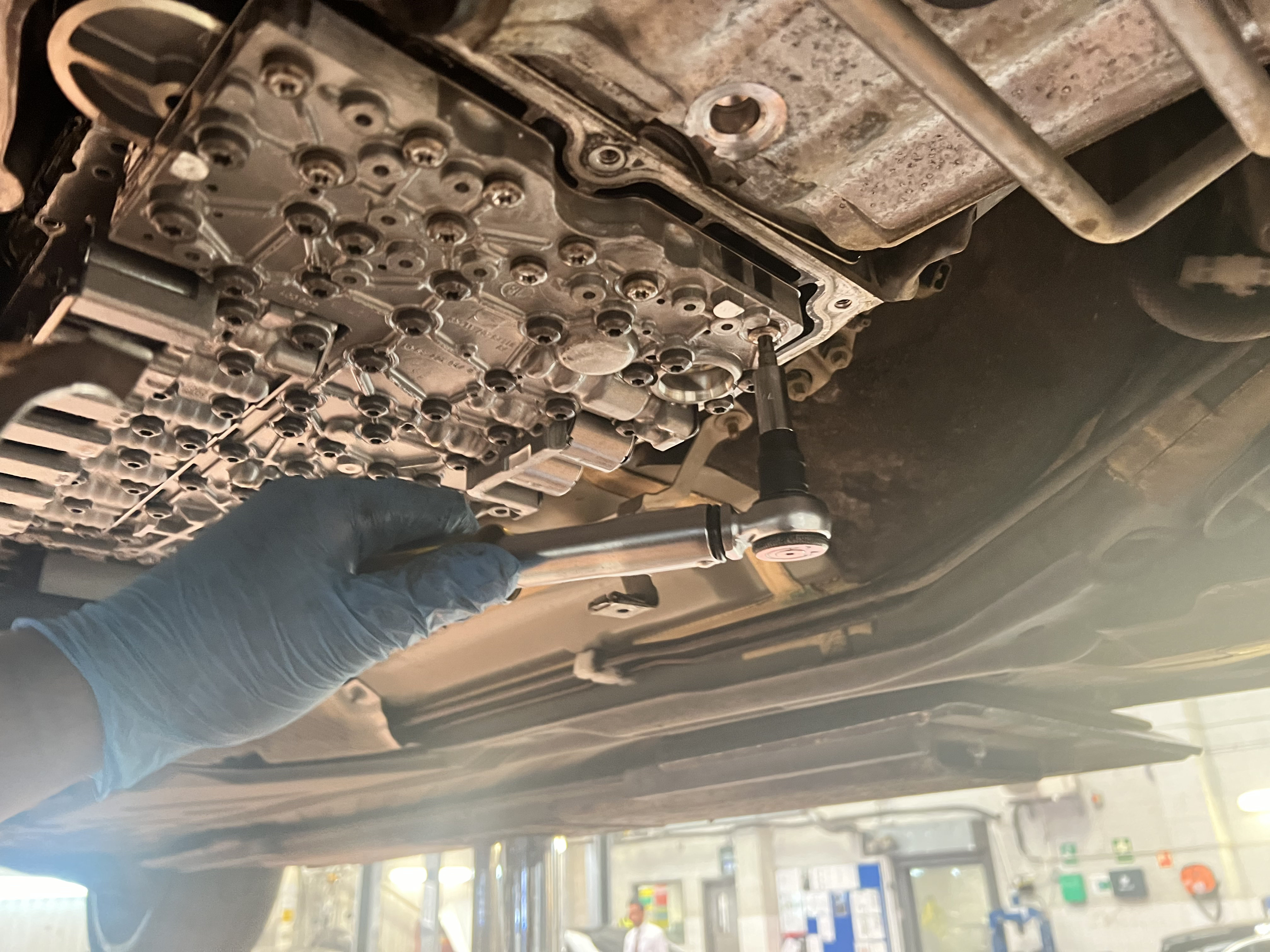 Torque wrench set to manufacturer specification on transmission drain plug