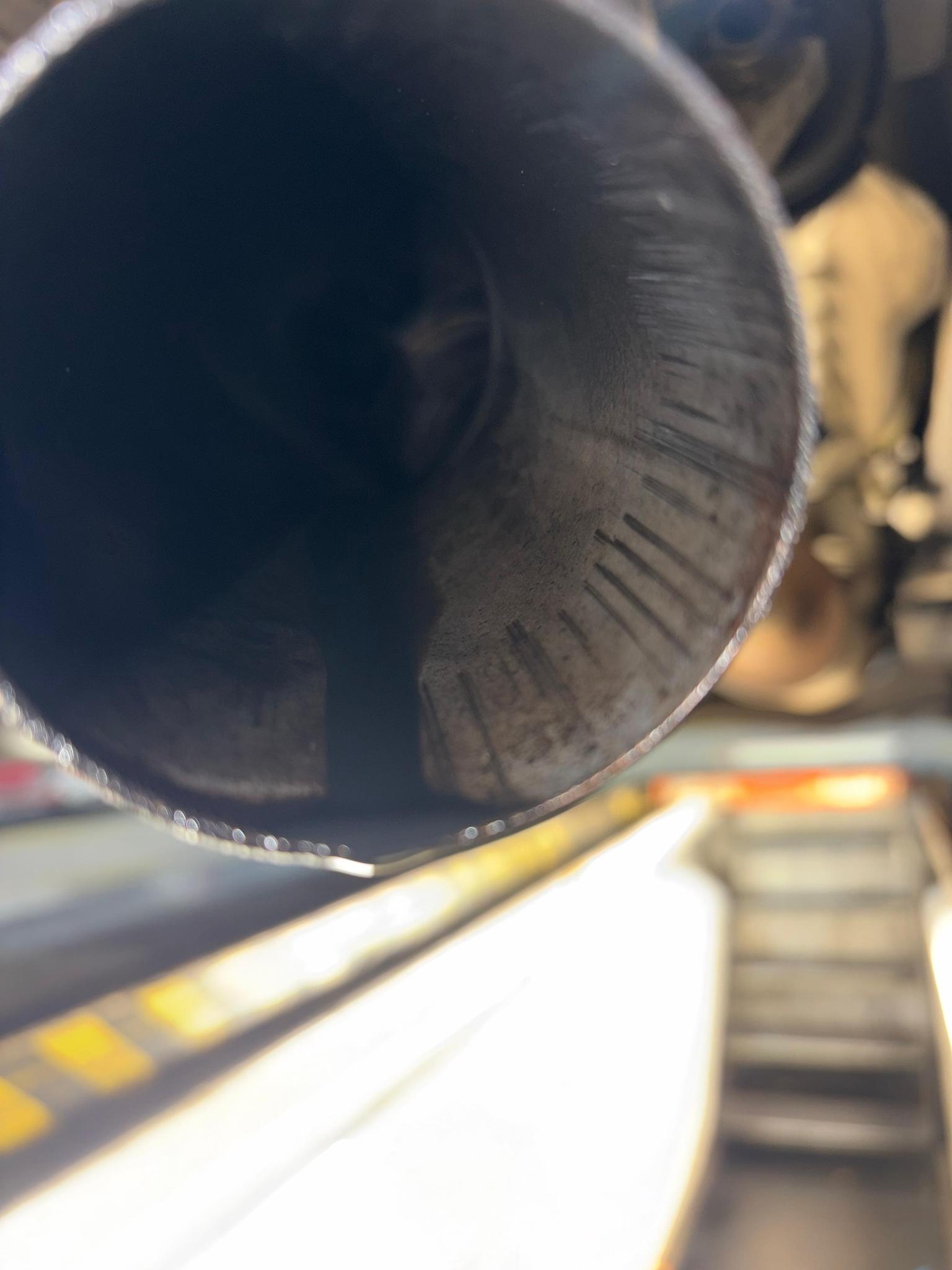Visible oil residue in exhaust tailpipe indicating severe turbo oil migration on Mercedes