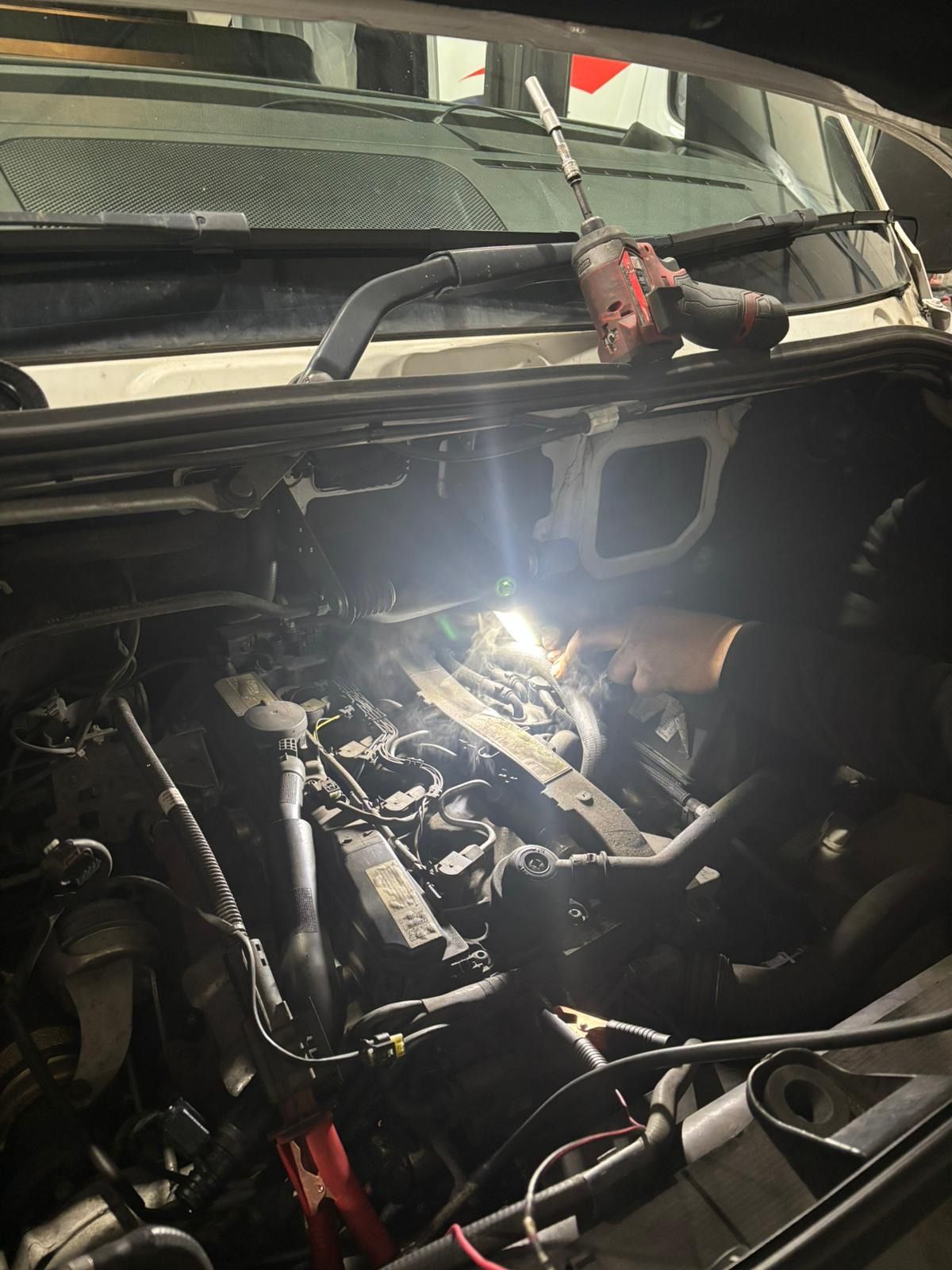 Sprinter engine bay inspection with Milwaukee impact driver and inspection light