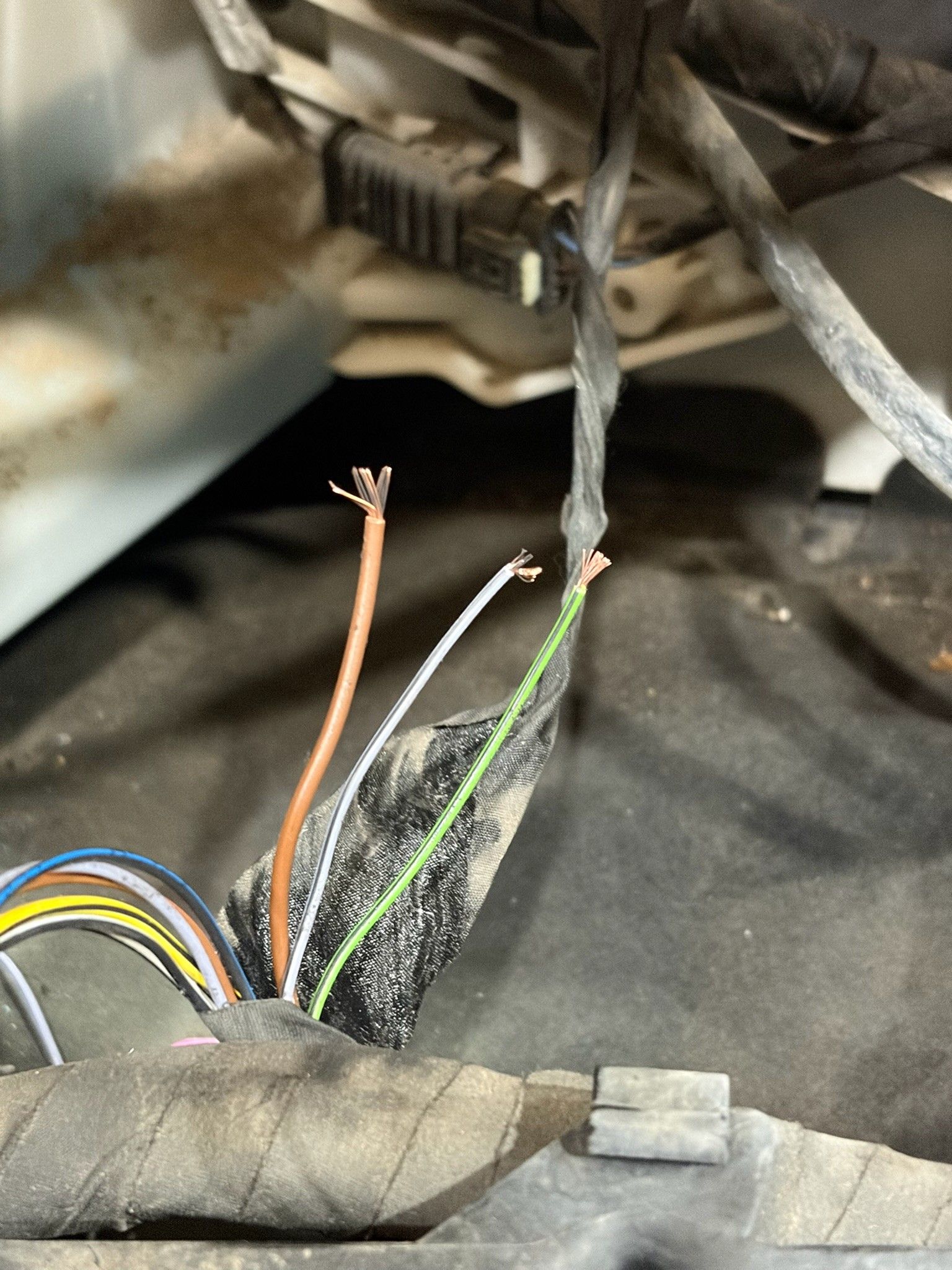 Frayed wiring harness with severed wires from vehicle chassis