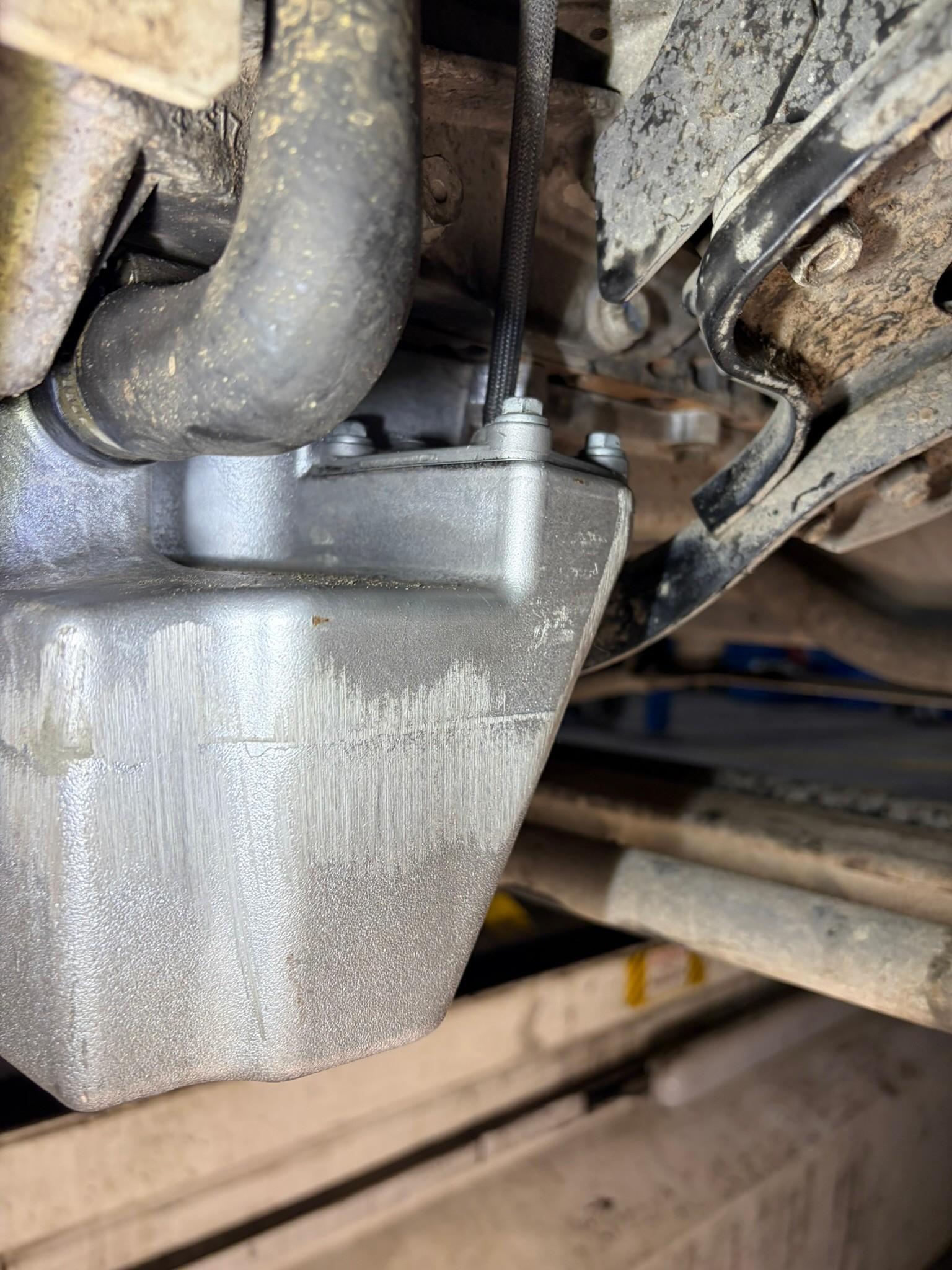 Undercarriage engine oil pan with scuffing damage