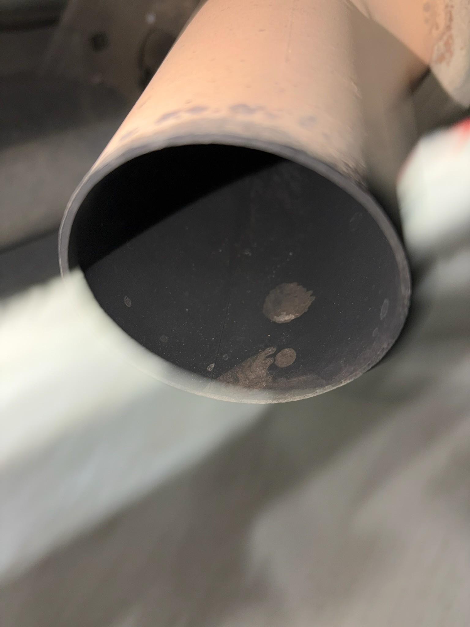 Sooty exhaust tailpipe showing carbon deposits for emissions check