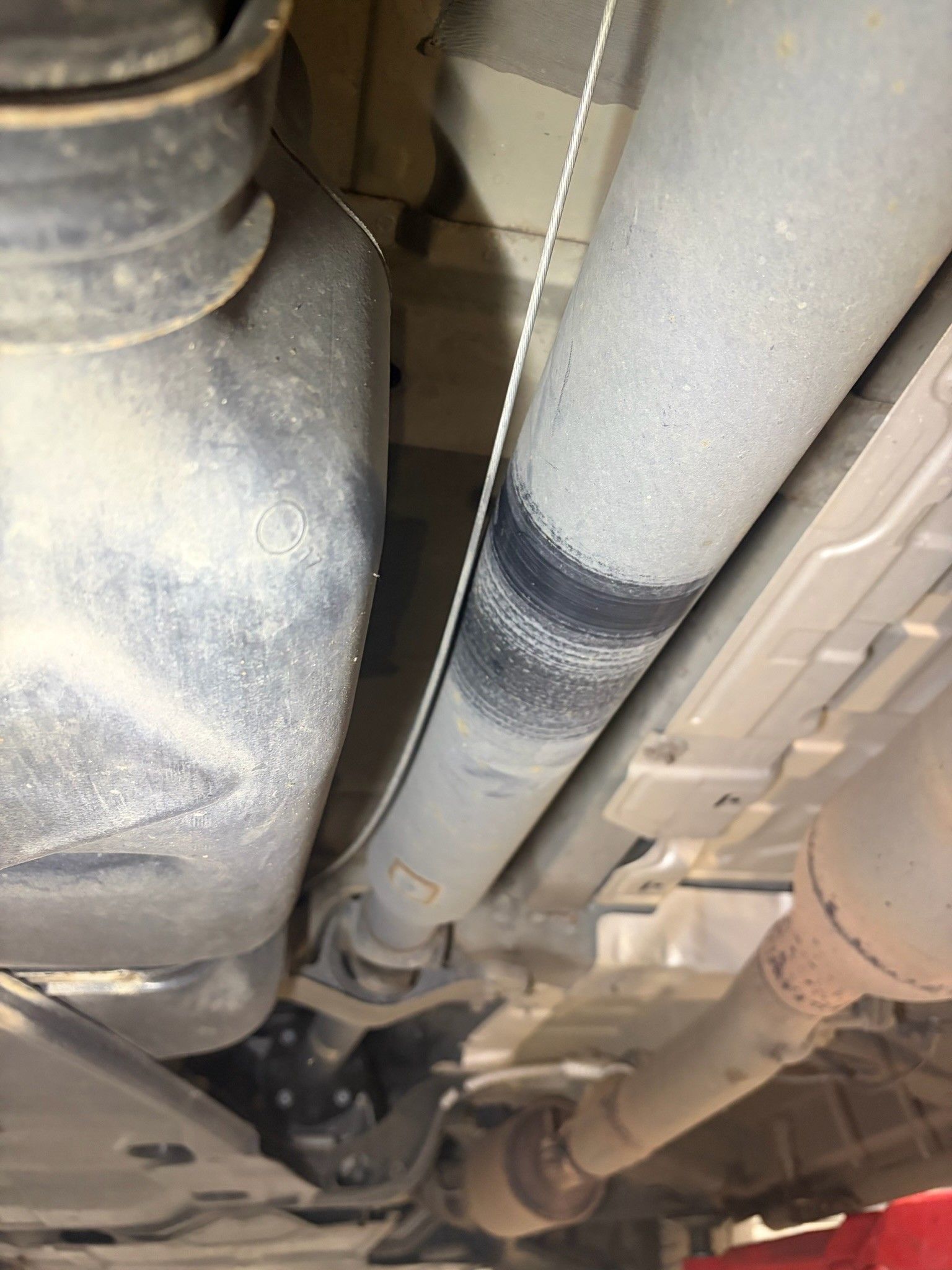 Under-chassis view of driveshaft exhaust and fuel tank