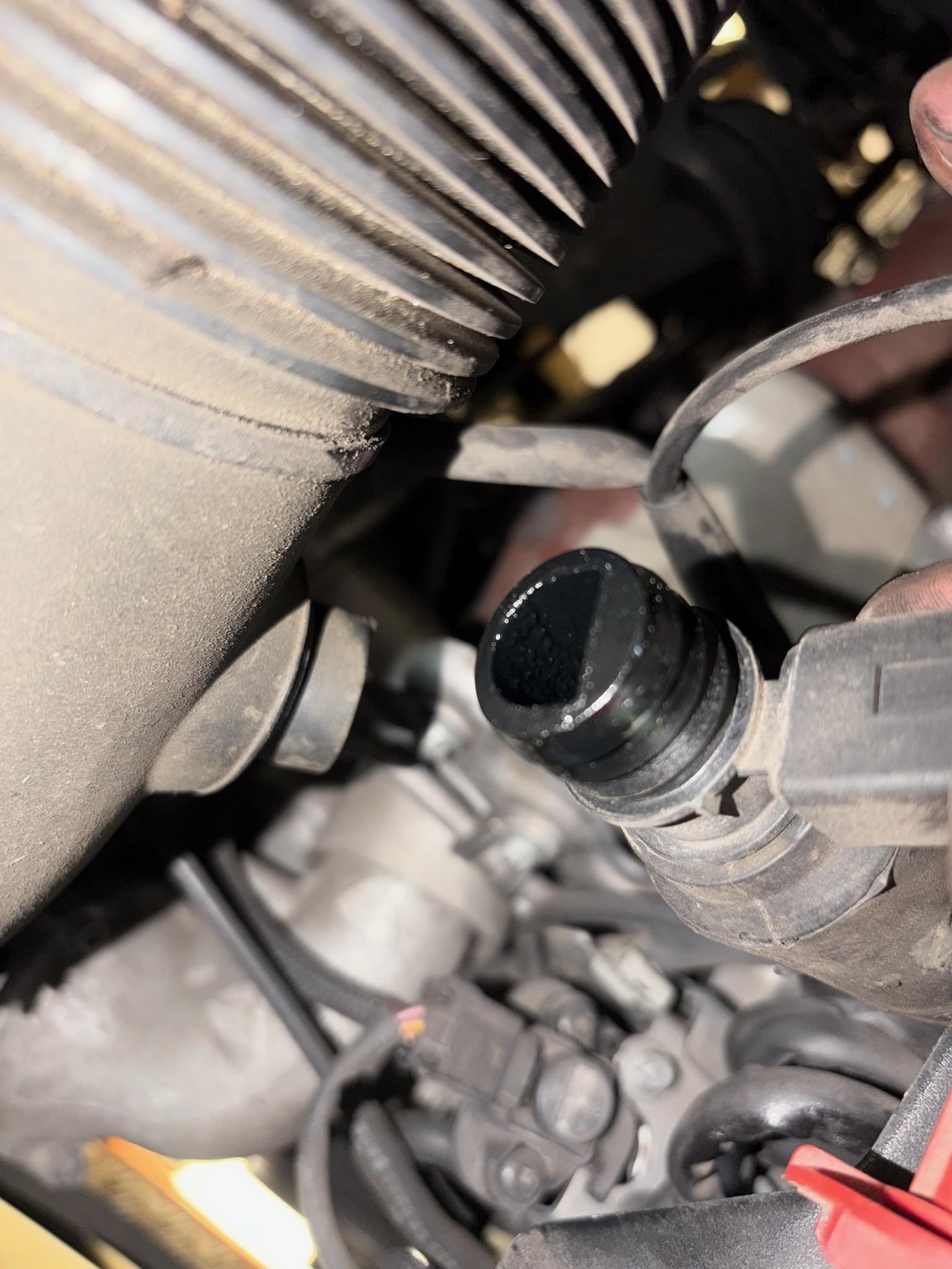 Oily intake sensor showing carbon build-up in engine bay