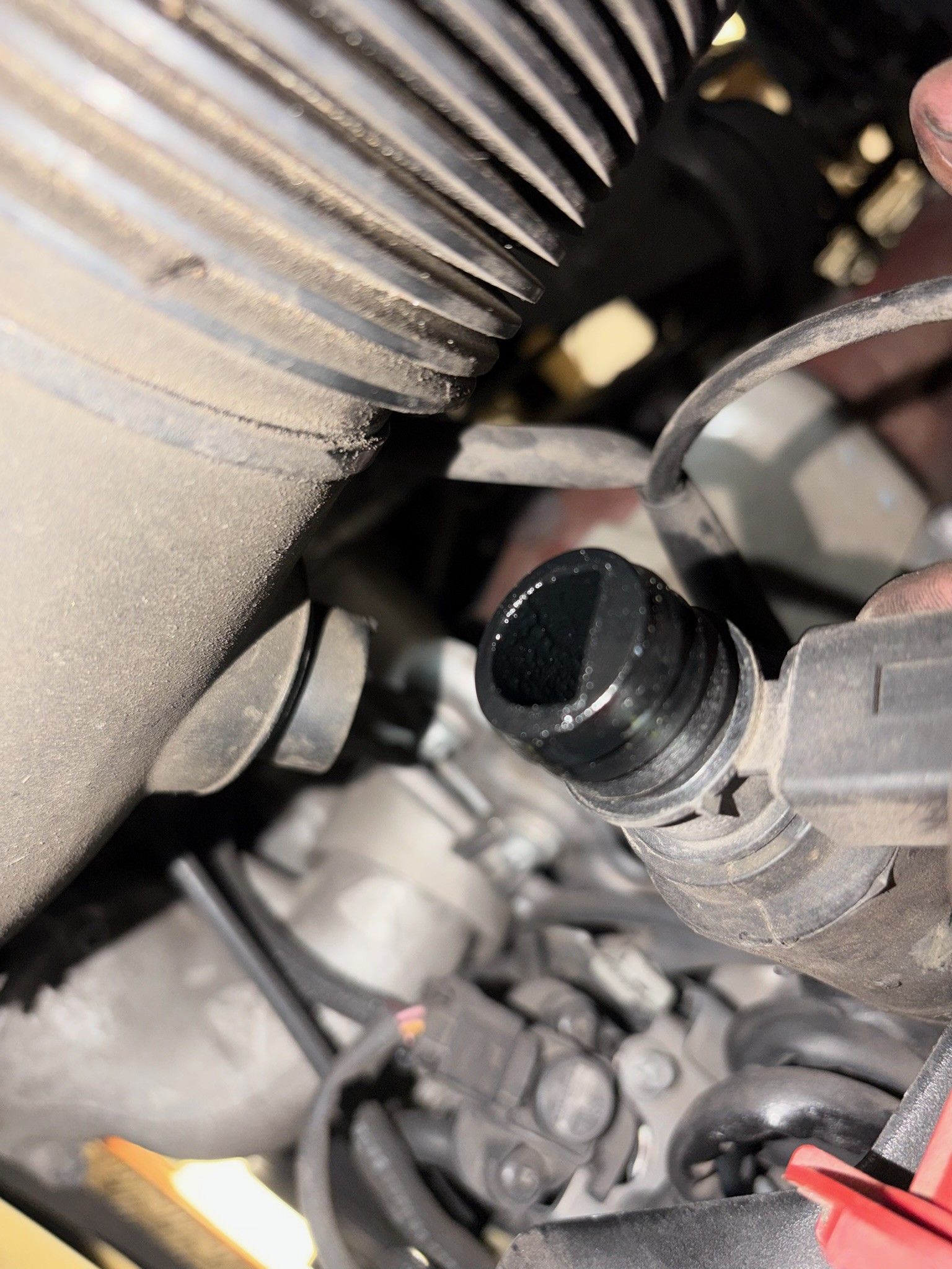 Oily intake sensor showing carbon build-up in engine bay