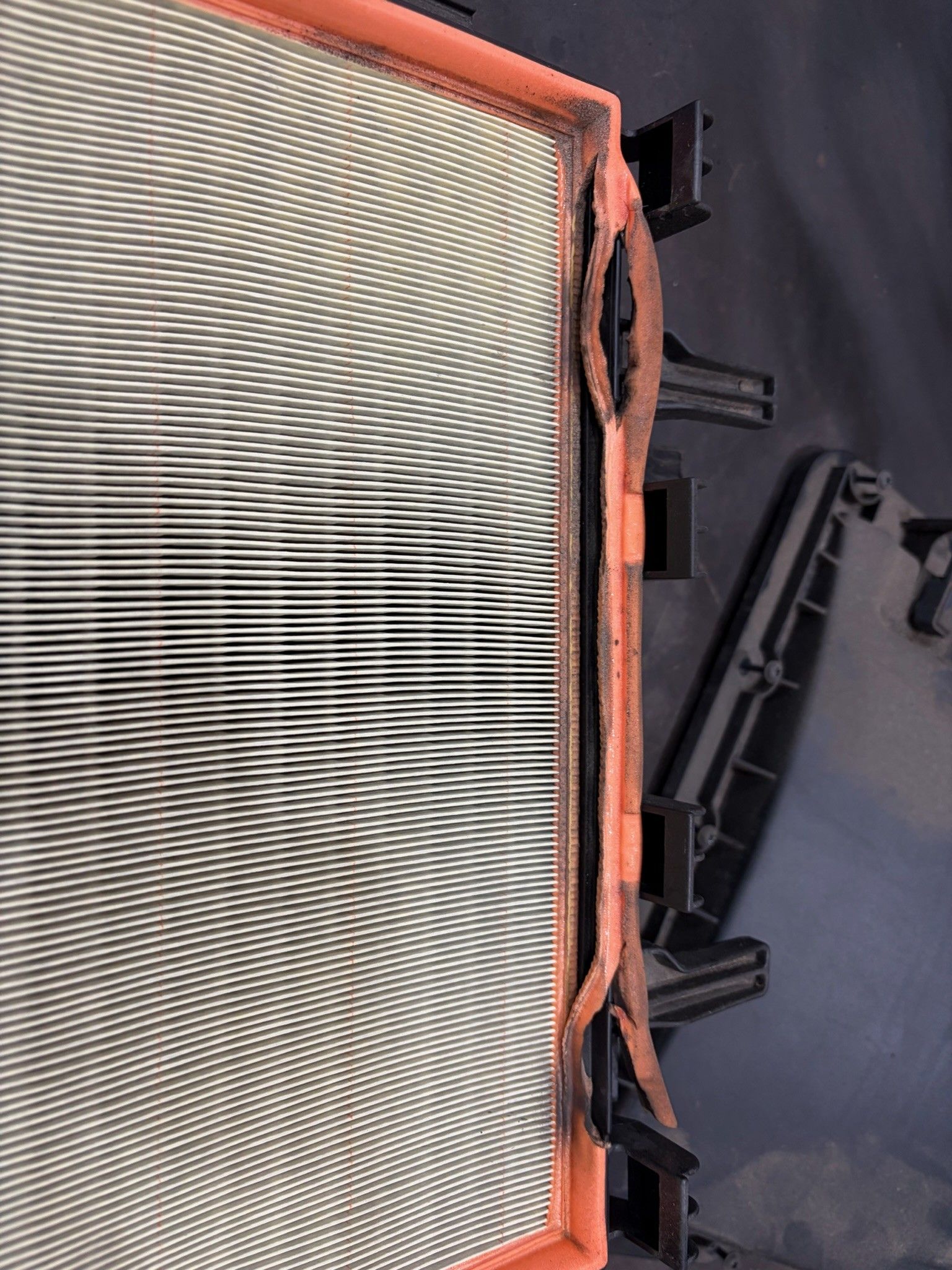 Damaged engine air filter with torn seal and warped media