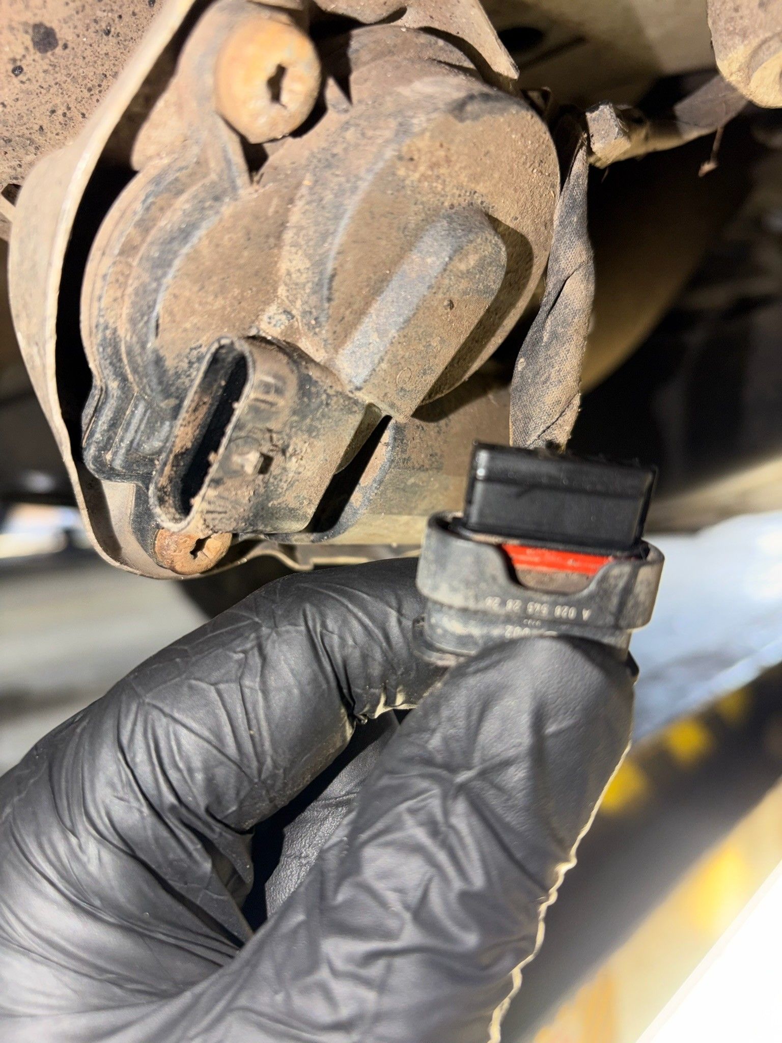 Mercedes harness plug with red weather seal under vehicle