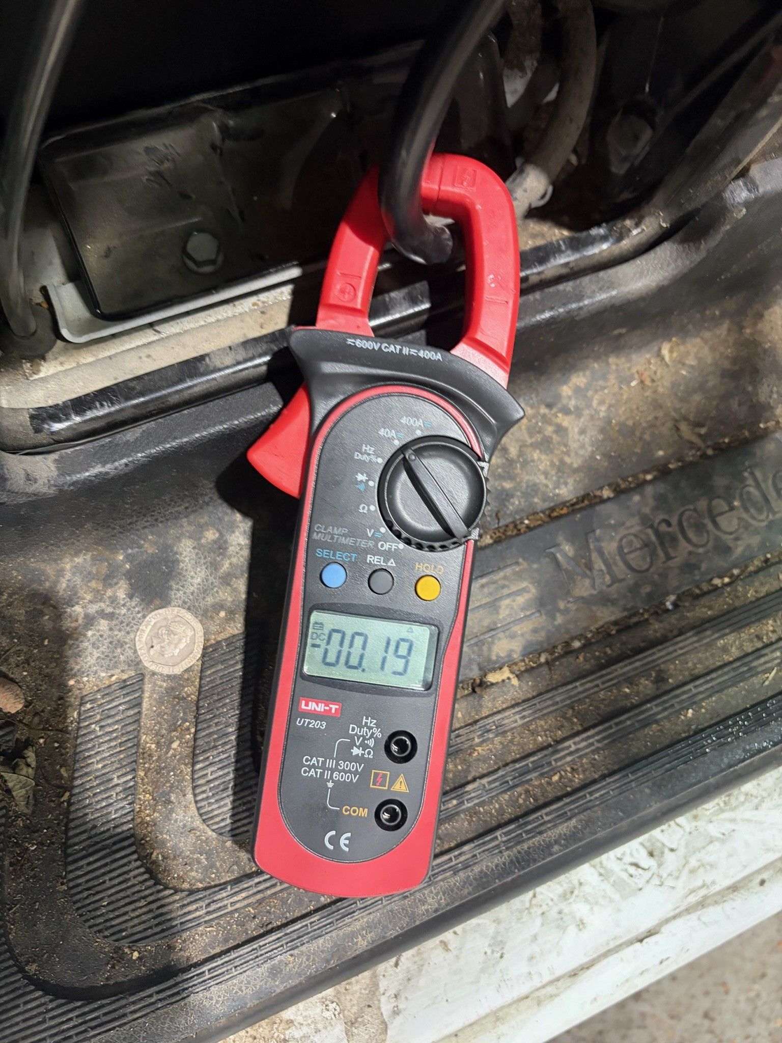 UNI-T clamp multimeter measuring parasitic draw on Mercedes door sill
