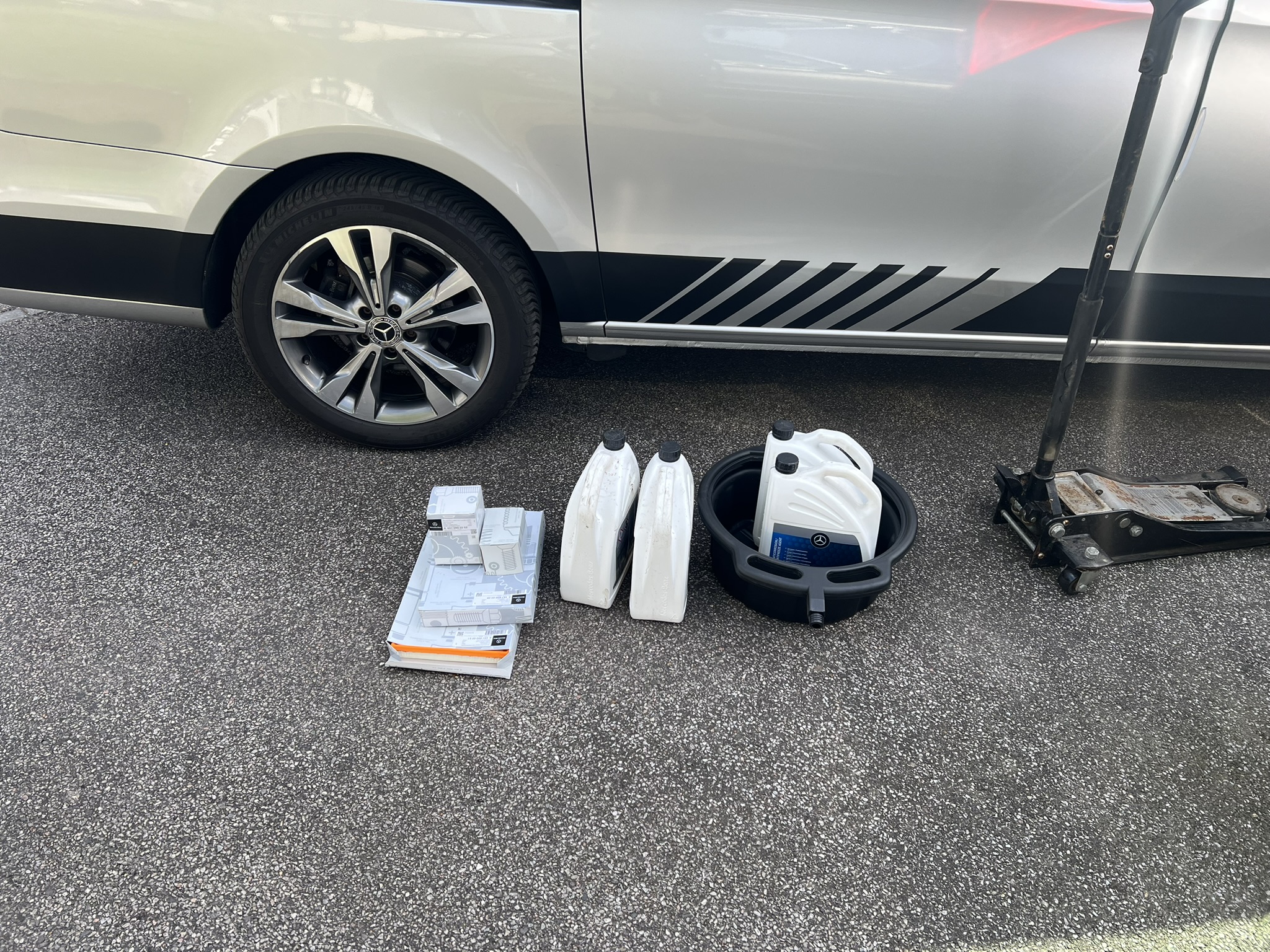 Genuine Mercedes parts laid out next to a van before a mobile service